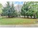 Landscaped backyard featuring lush lawn, a wrought iron fence, and mature trees for privacy at 13030 Dartmore Ave, Alpharetta, GA 30005