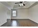 Spacious bedroom featuring dark hardwood floors, ceiling fan, and a tray ceiling at 13030 Dartmore Ave, Alpharetta, GA 30005