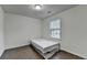 This bedroom has a window for natural light, dark wood floors, and white walls at 13030 Dartmore Ave, Alpharetta, GA 30005