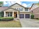 Inviting two-story home with a covered front porch and a two-car garage at 13030 Dartmore Ave, Alpharetta, GA 30005