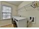 This laundry room features a window for natural light, a washer and dryer, and a shelf at 13030 Dartmore Ave, Alpharetta, GA 30005
