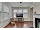 Cozy living room with a fireplace and view of the backyard through bright and airy windows at 13030 Dartmore Ave, Alpharetta, GA 30005
