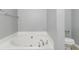 Bright bathroom featuring a luxurious soaking tub and modern toilet at 4811 Westgate Blvd, Atlanta, GA 30349
