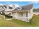 Charming, yellow home featuring a cozy front porch, neat landscaping, and a classic architectural style at 4811 Westgate Blvd, Atlanta, GA 30349