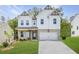 Inviting two-story home showcasing a modern farmhouse design with a pristine lawn and elegant architectural details at 5109 Hillside Haven Dr, Powder Springs, GA 30127