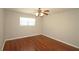 Bright bedroom featuring gleaming hardwood floors, and a ceiling fan light fixture at 5415 Keithwood Dr, Cumming, GA 30040