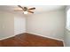 Bedroom with closet, ceiling fan and light, and window with wood-look floors at 5415 Keithwood Dr, Cumming, GA 30040