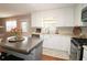 Bright kitchen featuring white cabinets, stainless steel appliances, and an island with a stainless countertop at 5415 Keithwood Dr, Cumming, GA 30040