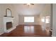 A spacious living room featuring hardwood floors, a fireplace, vaulted ceilings, and natural light, creating an inviting atmosphere at 5415 Keithwood Dr, Cumming, GA 30040