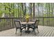 Outdoor patio featuring dining table, seating, and wooded scenery at 5415 Keithwood Dr, Cumming, GA 30040