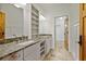 A bathroom featuring dual sinks, granite counters, cabinet storage, tile floor, and a doorway at 176 Stewart Nw Ave, Marietta, GA 30064