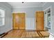 Bedroom features a large window, natural light, beautiful wood floors, and closet with wooden doors at 176 Stewart Nw Ave, Marietta, GA 30064