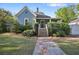 Inviting home with stone pathway leading to a covered porch, enhanced by neatly trimmed hedges and a green lawn at 176 Stewart Nw Ave, Marietta, GA 30064
