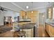 Kitchen with light wood cabinets, granite countertops, stainless appliances, and open access to the living room at 176 Stewart Nw Ave, Marietta, GA 30064