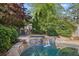 Backyard pool featuring a rock waterfall feature and lush surrounding greenery at 176 Stewart Nw Ave, Marietta, GA 30064