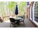 Back deck of home with table, umbrella, and wooden deck overlooking trees at 1886 Chedworth Ct, Stone Mountain, GA 30087
