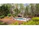 Expansive backyard view with pool, gazebo, lush landscaping, and towering trees at 1886 Chedworth Ct, Stone Mountain, GA 30087