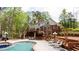 Manicured backyard with in-ground pool, mature trees, and patio seating areas at 1886 Chedworth Ct, Stone Mountain, GA 30087
