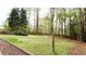 Spacious backyard with lush green grass, mature trees, and wooded surroundings at 1886 Chedworth Ct, Stone Mountain, GA 30087