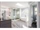Modern bathroom with glass shower, soaking tub under skylight, and elegant gray tile at 1886 Chedworth Ct, Stone Mountain, GA 30087