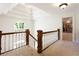 Upstairs hallway with hardwood railing, chandelier, and lots of natural light at 1886 Chedworth Ct, Stone Mountain, GA 30087