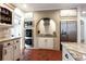 Kitchen featuring brick archway with cooktop, stainless appliances, granite counters, and custom cabinetry at 1886 Chedworth Ct, Stone Mountain, GA 30087