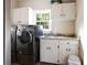 Functional laundry room with modern washer/dryer and ample cabinet space at 1886 Chedworth Ct, Stone Mountain, GA 30087