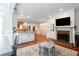 Open living area with fireplace, brick hearth, TV, brick flooring, and view of the kitchen at 1886 Chedworth Ct, Stone Mountain, GA 30087