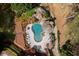 Aerial view of a kidney-shaped pool with a patio, lounge chairs, and lush landscaping at 1886 Chedworth Ct, Stone Mountain, GA 30087