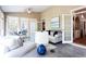 Bright sun room with laminate flooring, multiple windows, ceiling fan, and access to the kitchen at 1886 Chedworth Ct, Stone Mountain, GA 30087