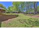 Landscaped backyard with retaining walls and established trees at 2865 Maple Vista Ln, Lawrenceville, GA 30044