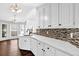 Bright kitchen featuring white cabinetry, granite countertops, and a stylish tile backsplash at 2865 Maple Vista Ln, Lawrenceville, GA 30044