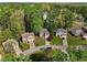 Aerial view of houses with well-manicured lawns, mature trees and long driveways at 6960 Dockbridge Way, Stone Mountain, GA 30087