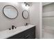 Modern bathroom featuring a double vanity, matte black fixtures, round mirrors, and a shower-tub combo at 6960 Dockbridge Way, Stone Mountain, GA 30087
