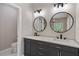 This primary bathroom includes dual sinks, large mirrors, and modern lighting fixtures at 6960 Dockbridge Way, Stone Mountain, GA 30087