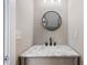 Stylish bathroom with a marble countertop vanity, black faucet, and minimalist round mirror at 6960 Dockbridge Way, Stone Mountain, GA 30087