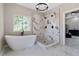 Modern bathroom featuring a soaking tub, marble shower, and sleek fixtures, creating a spa-like retreat at 6960 Dockbridge Way, Stone Mountain, GA 30087