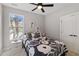 Bedroom with a ceiling fan, window, and closet. Floral bedspread and monochrome decor provide modern style at 6960 Dockbridge Way, Stone Mountain, GA 30087