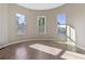 Sunlit empty bedroom with three large windows and light hardwood flooring creating a bright and airy feel at 6960 Dockbridge Way, Stone Mountain, GA 30087