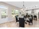 Bright dining area with a modern light fixture, hardwood floors, and seamless access to the kitchen at 6960 Dockbridge Way, Stone Mountain, GA 30087