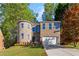 Beautiful two-story brick home with a stone turret, manicured lawn, and attached two-car garage at 6960 Dockbridge Way, Stone Mountain, GA 30087