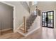 Bright foyer featuring hardwood floors, stairs with black railings, and a modern front door with glass panels at 6960 Dockbridge Way, Stone Mountain, GA 30087