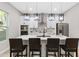 Modern kitchen featuring a large island with seating, stainless steel appliances, and stylish pendant lighting at 6960 Dockbridge Way, Stone Mountain, GA 30087
