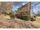 View of a backyard with mature landscaping, a deck, and string lights at 11570 Dunhill Place Dr, Johns Creek, GA 30005