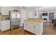 Open kitchen area features an island and stainless steel refrigerator with hardwood floors at 11570 Dunhill Place Dr, Johns Creek, GA 30005