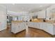 Spacious kitchen with island, white cabinets, stainless appliances, and hardwood flooring at 11570 Dunhill Place Dr, Johns Creek, GA 30005