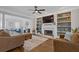 Bright living room featuring a fireplace, built-in bookshelves, and lots of seating at 11570 Dunhill Place Dr, Johns Creek, GA 30005