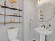 This powder room has a pedestal sink, floating shelves, and modern fixtures at 11570 Dunhill Place Dr, Johns Creek, GA 30005