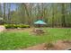 Backyard with manicured hedges, wooden furniture, and a blue umbrella at 440 Old Homestead Trl, Johns Creek, GA 30097