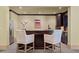 A home bar area with dark wood cabinets, light countertops, a stainless steel refrigerator, and a sculpture at 440 Old Homestead Trl, Johns Creek, GA 30097